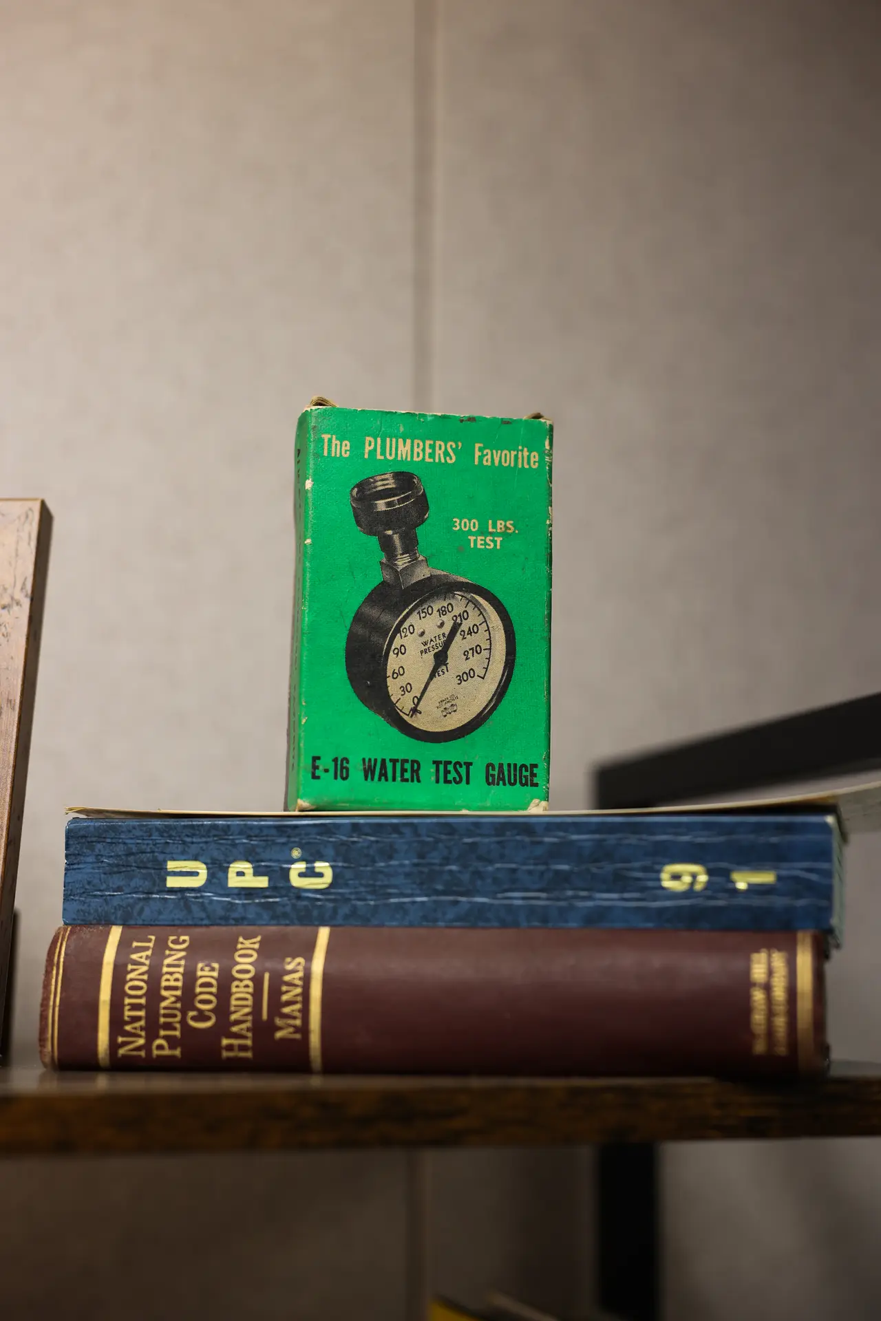 Vintage water pressure test gauge box sitting on plumbing code books