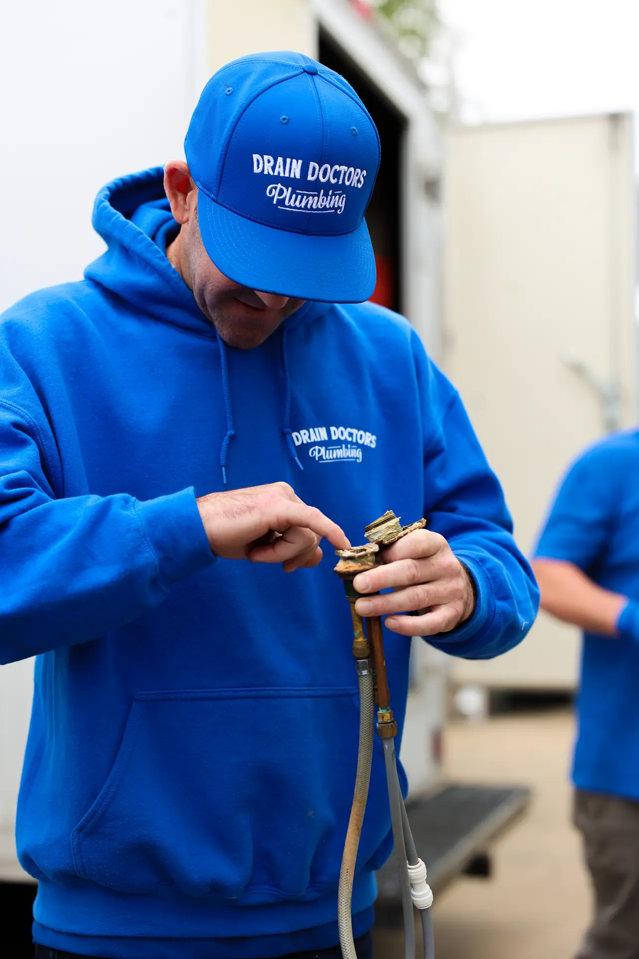 Drain Doctors Plumbing technician holding a new water supply line