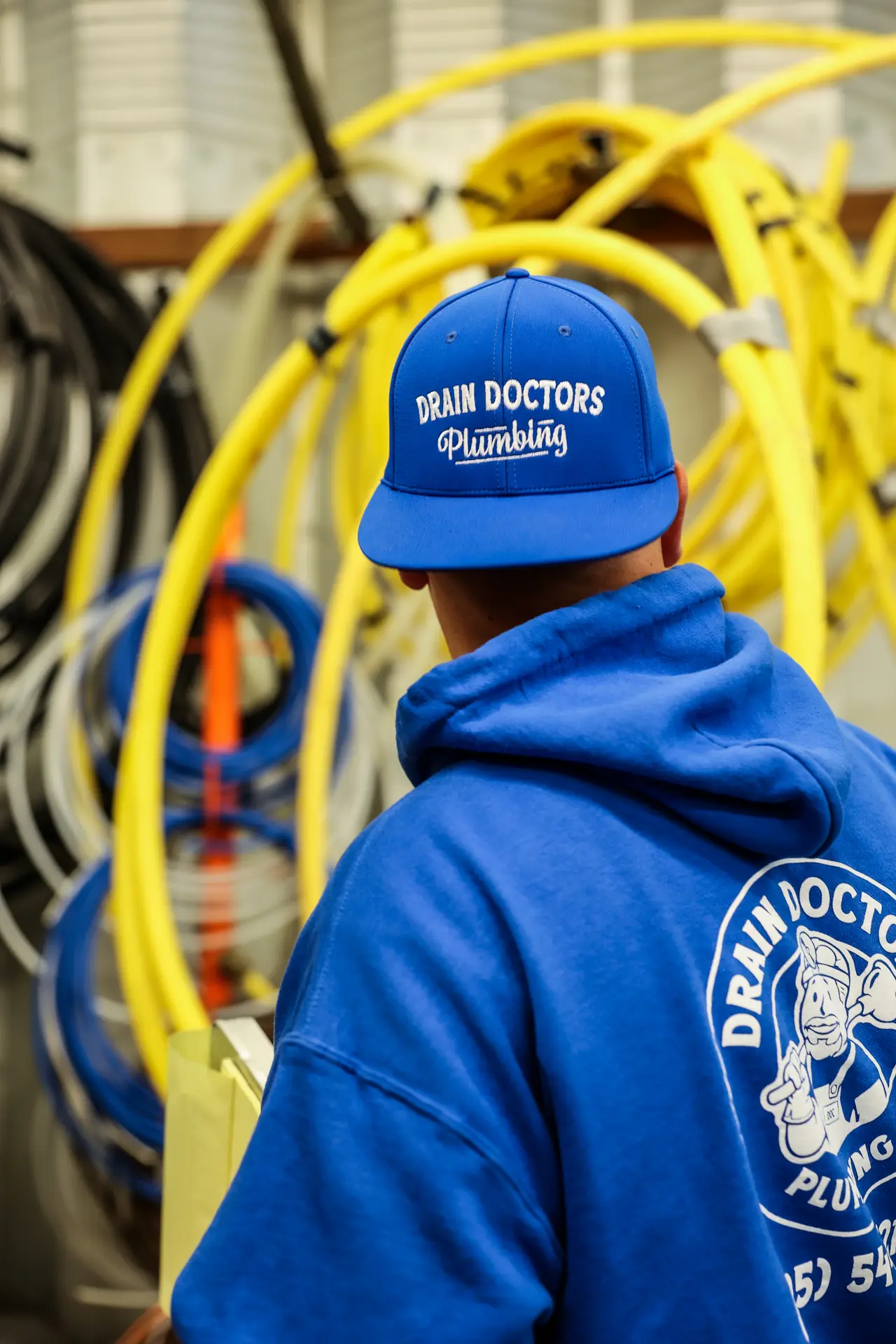 Drain Doctors Plumbing technician in front of coils of yellow flexible gas line in the shop